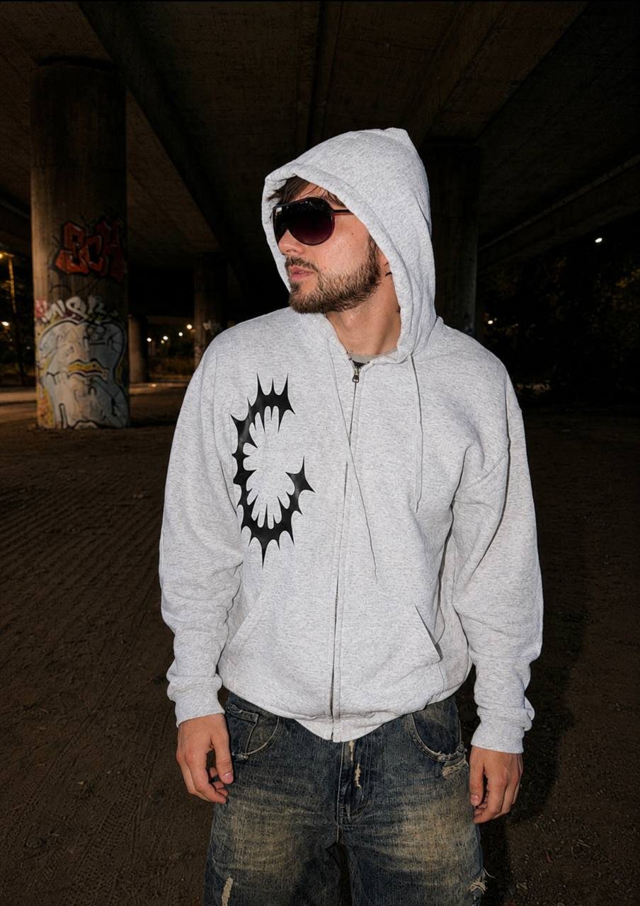 German Wasteland Sigil Zip-Up Hoodie front streetwear photo with grey hoodie, black sigil chest graphic, sunglasses and night underpass setting