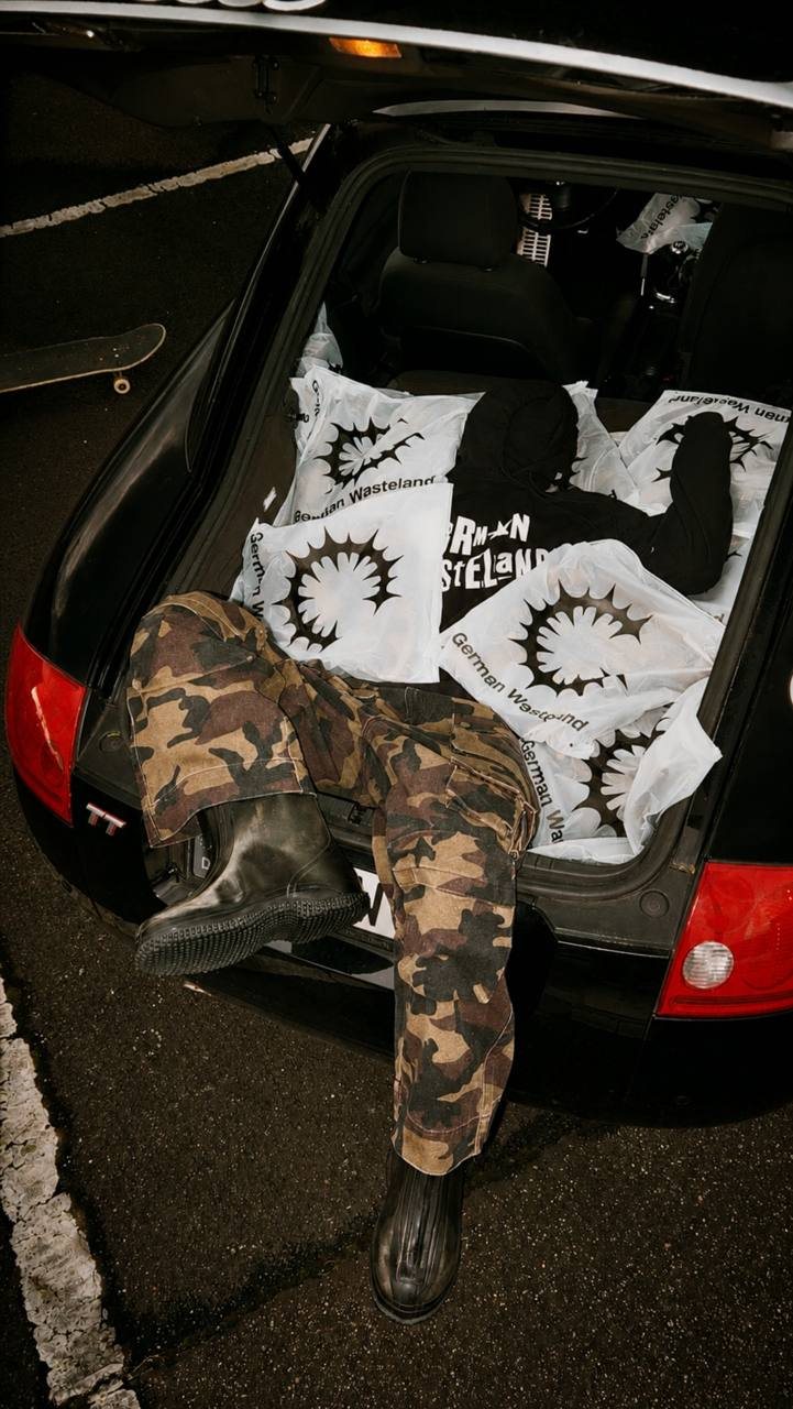 German Wasteland grey Sigil Zip-Up Hoodie streetwear photo with sunglasses, oversized denim and underpass night setting
